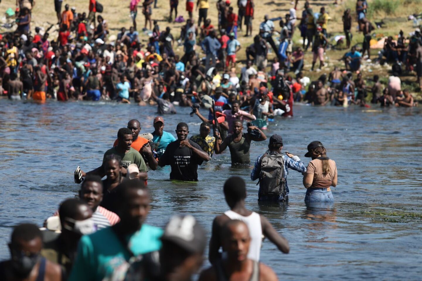 Haitianos cruzan el río Bravo del lado texano hacia suelo mexicano para conseguir comida y víveres. Los migrantes permanecen desde hace varios días en un campamento instalado de lado estadounidense en espera de que aquella nación les brinde asilo político.