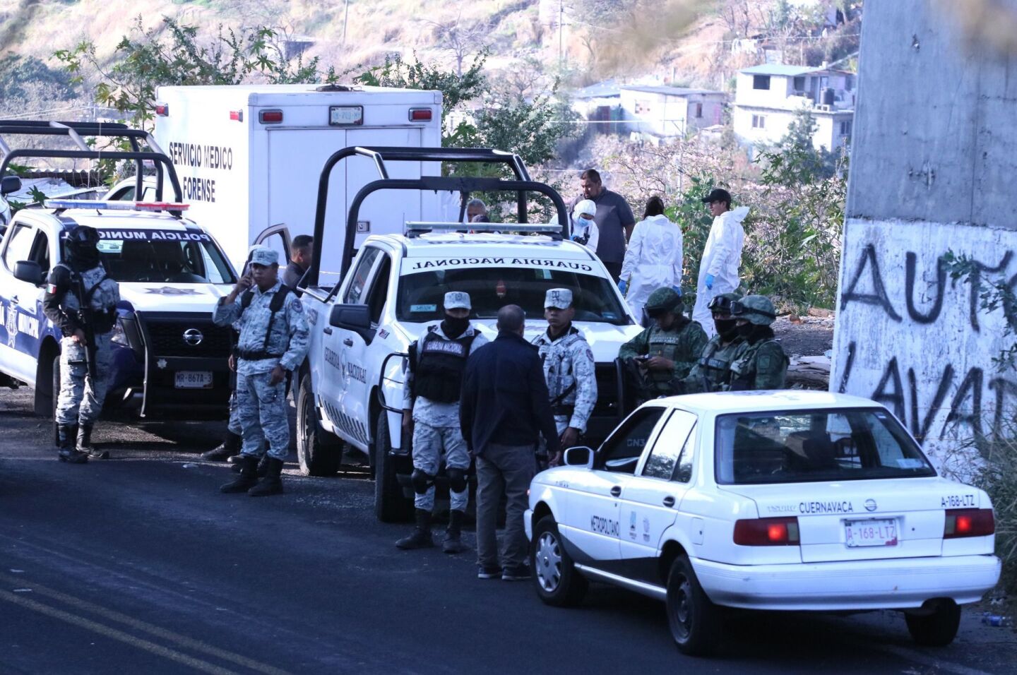 Elementos de la Guardia Nacional y del Ejercito colaboran en el acordonamiento de una escena de crimen donde fueron localizados tres cadáveres de hombres, al sur de la capital de Morelos.