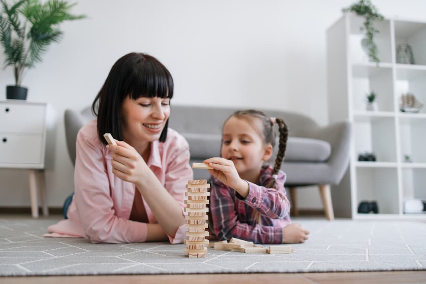 family-woman-and-kid-building-toy-tower-on-warm-fl-2023-11-27-05-28-06-utc (1)