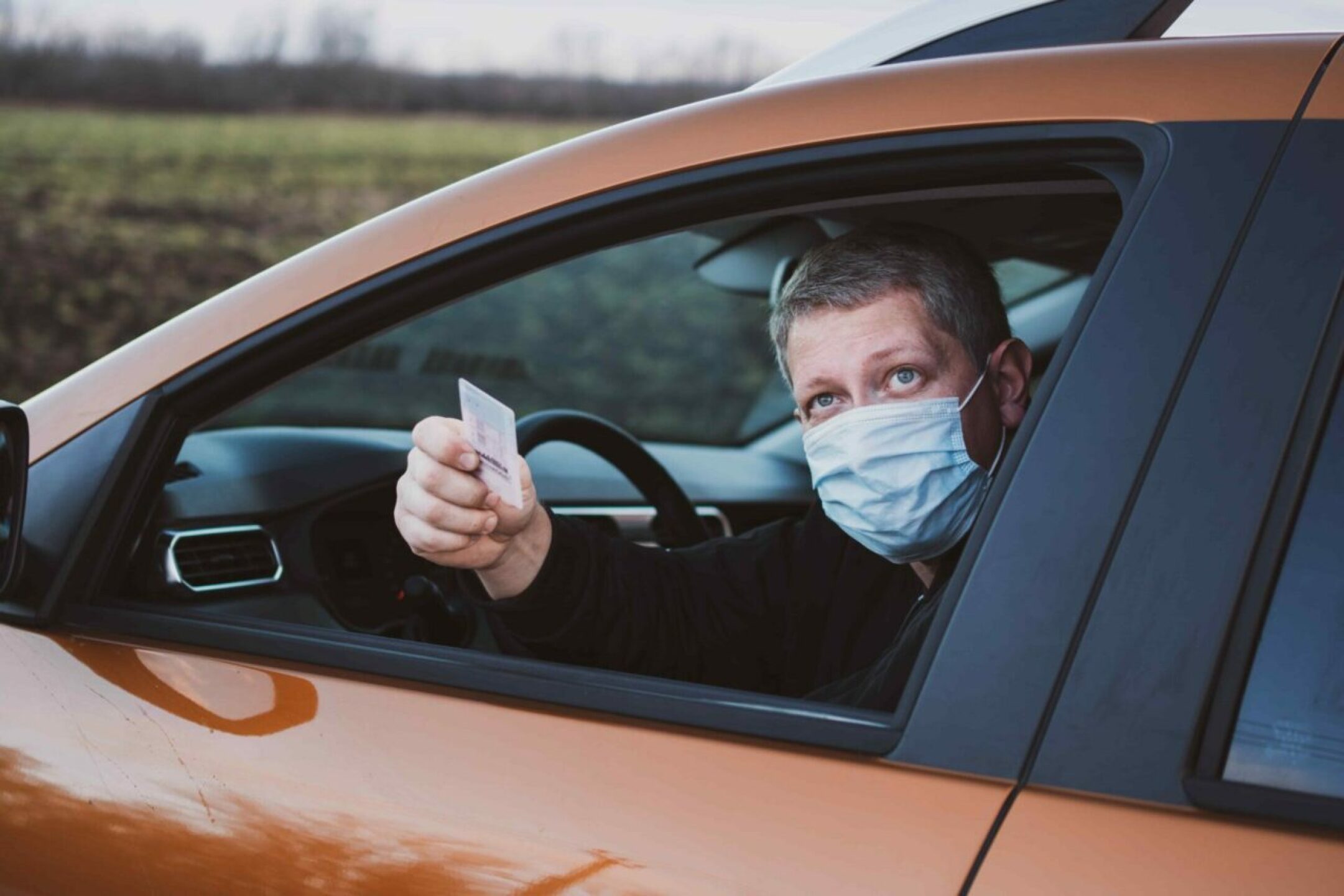 middle-aged-man-wearing-a-protective-mask-shows-hi-2022-11-14-20-05-13-utc-1280x853