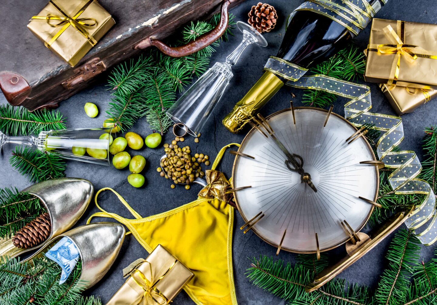 LATIN AMERICAN AND SPANISH NEW YEAR TRADITIONS. empty suitcase, lentil spoon, yellow interior clothes, gold ring in champagne, 12 grapes, money in shoe - CHILEAN MONEY. Christmas background