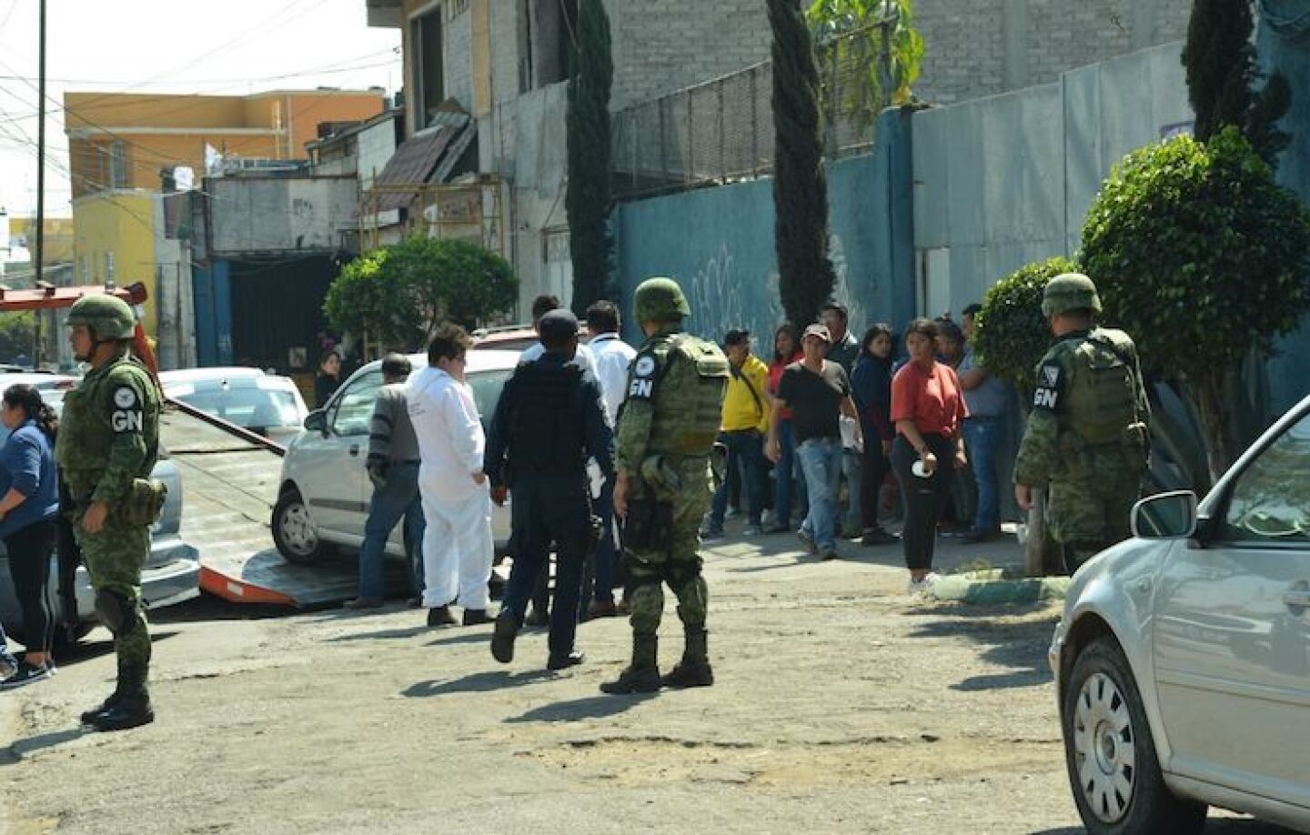 Elemetnos de la Guardia Nacional y de la Policía Municipal resguardan la escena donde fue encontrado el cuerpo sin vida de un hombre abordo de un vehículo.