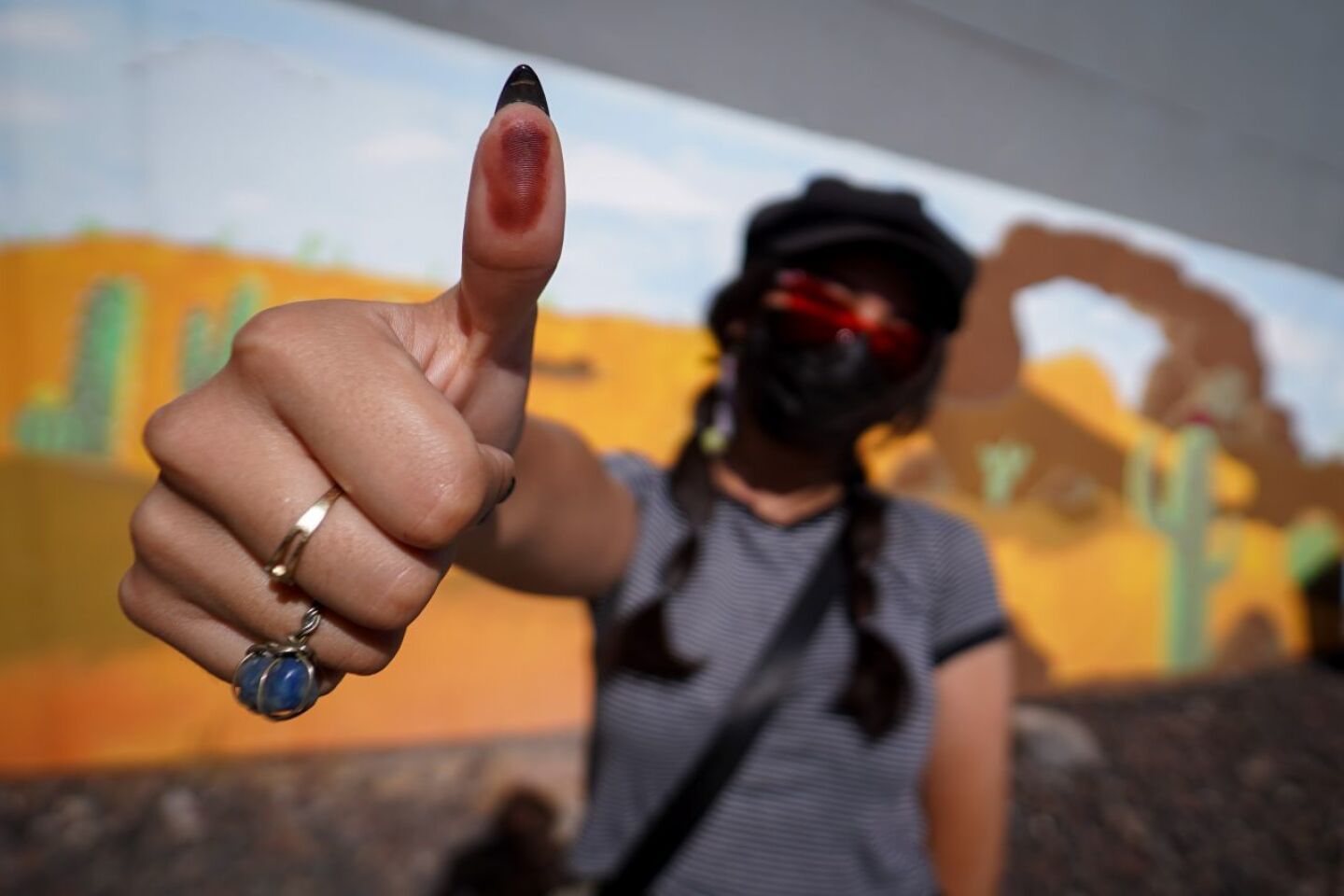 Una mujer muestra su pulgar pintado de tinta indeleble tras emitir su voto en Mexicali.