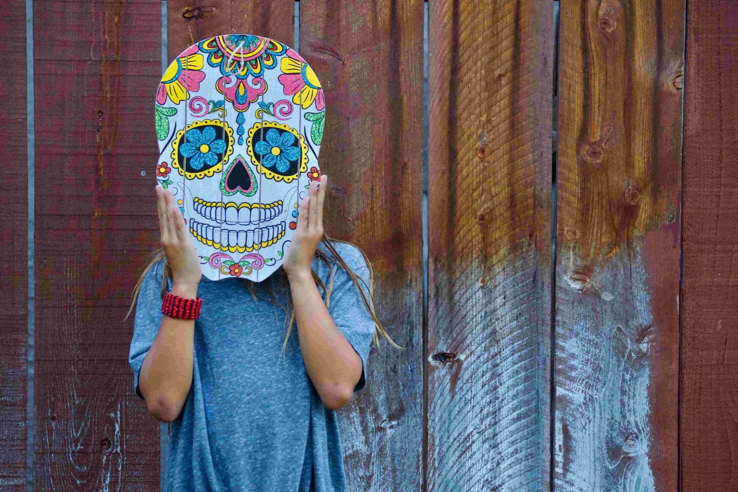person-holding-a-mexican-mask-over-her-face-for-da-2022-11-10-10-38-23-utc (1)