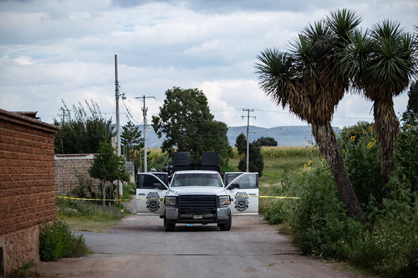 Policías de investigación y peritos de la Fiscalía General de Justicia del Estado entran y salen de una finca en la comunidad de Machines. En el lugar fueron encontrados diez cuerpos humanos semi enterrados en una fosa clandestina en el interior del in