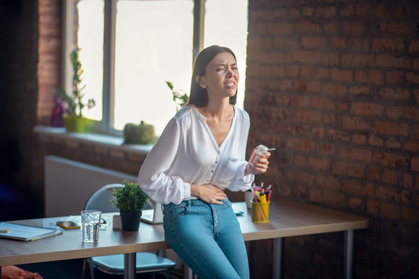 Nice unhappy young woman suffering from stomachache