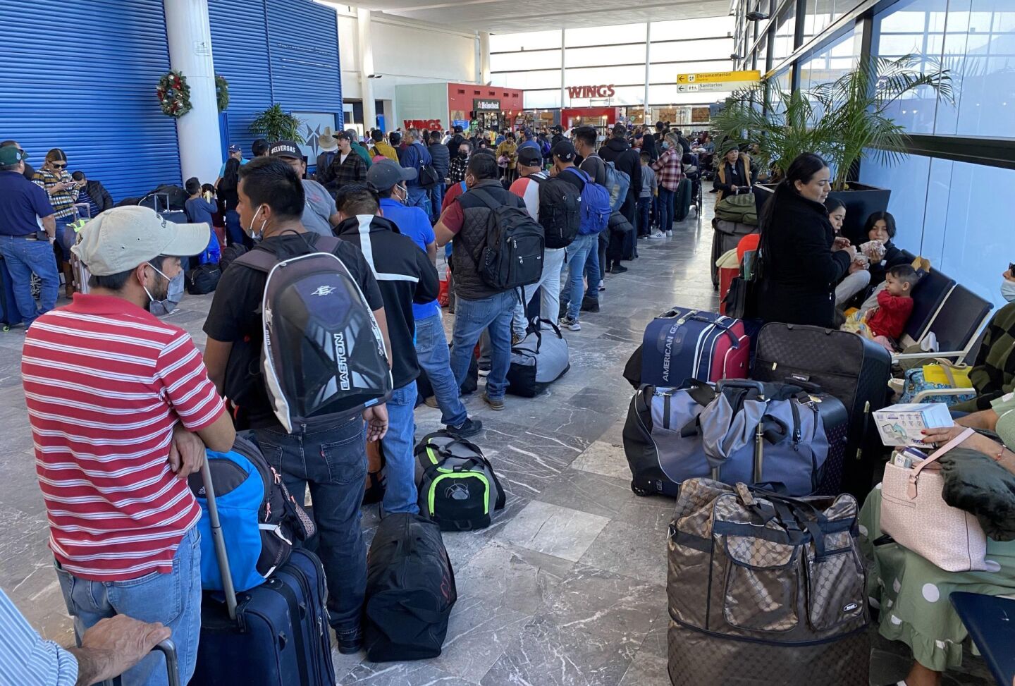 Personas en espera de que sean reprogramados de sus vuelos en el Aeropuerto Internacional de Tijuana.