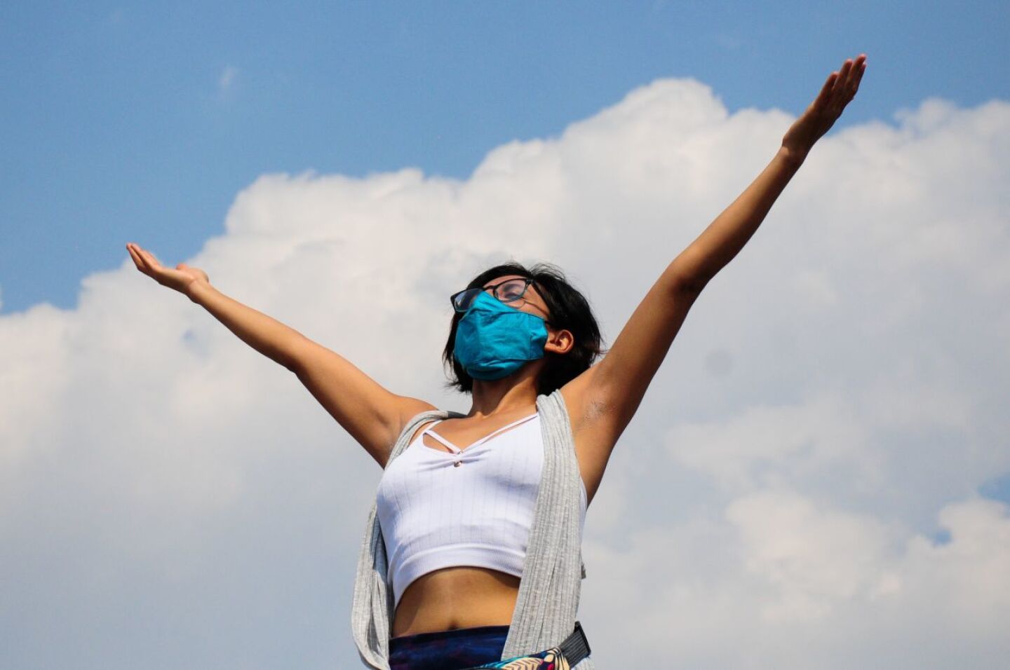 Una mujer alza los brazos al cielo para recargarse de energía en esta entrada de la primavera.