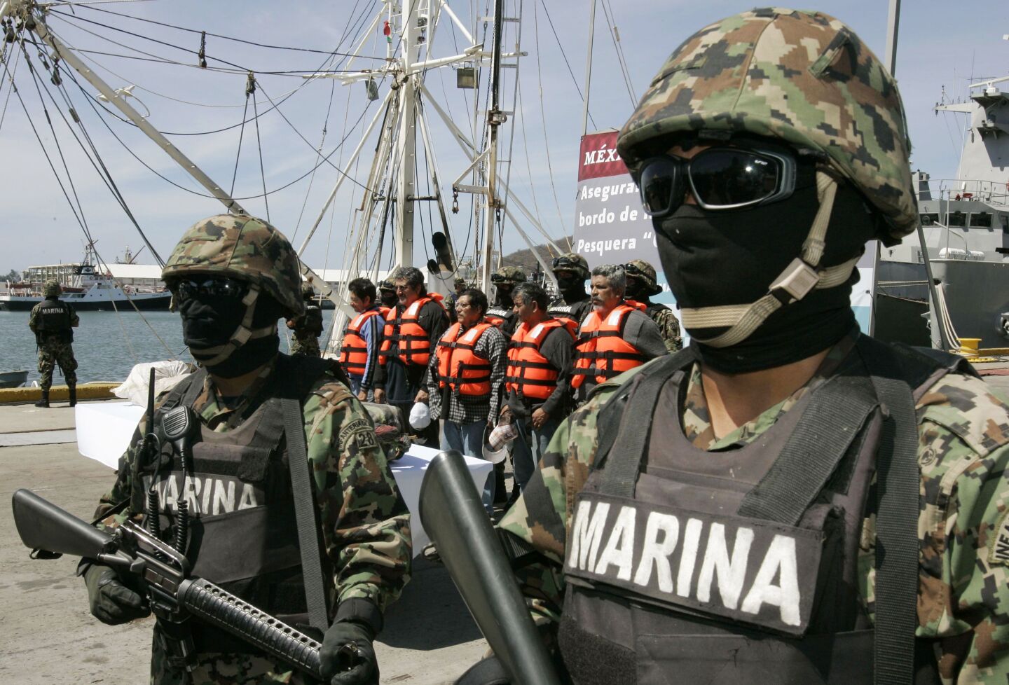 Mexican marines stand guard next to five arrested crew members  at a naval base in Salina Cruz in Mexico's state of Oaxaca