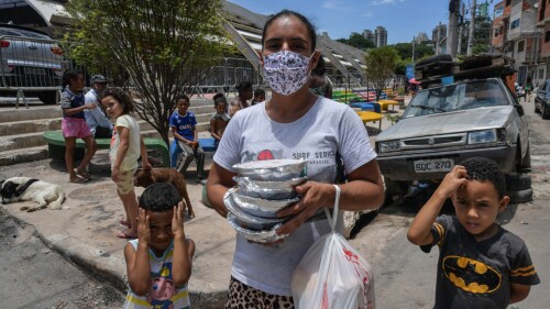 Celia da Costa Gomes, vive en la favela de Paraisopolis y camina con sus hijos rumbo a su casa luego de haber recibido comida, en Sao Paulo. Foto: NELSON ALMEIDA / AFP