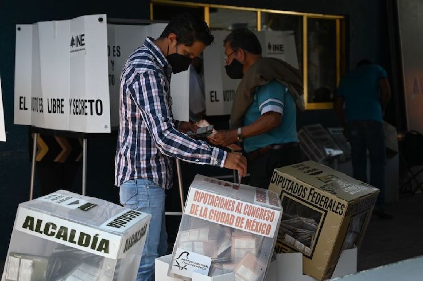 Dos habitantes de Iztapalapa colocan sus votos dentro de las urnas.