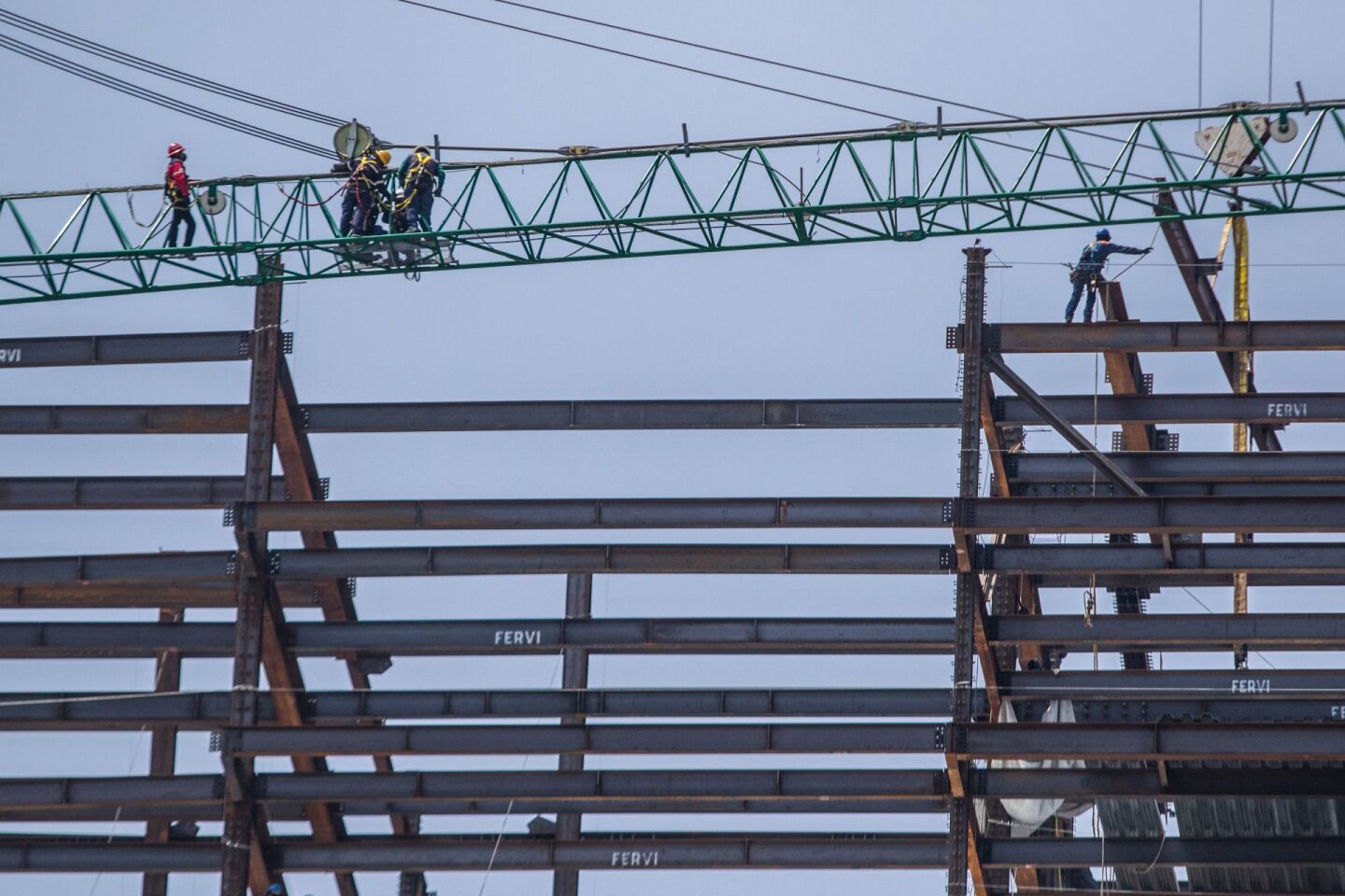 Obreros colocan vigas de acero para la construcción de un edifico en la colonia Tabacalera.