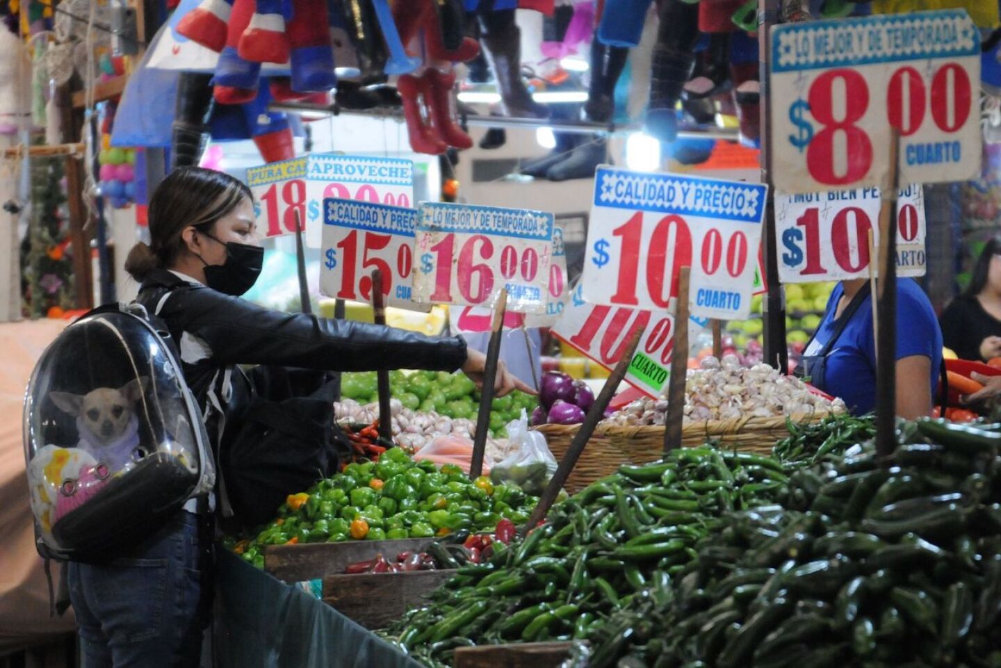 Una mujer compra vegetales en un local del Mercado Jamaica.