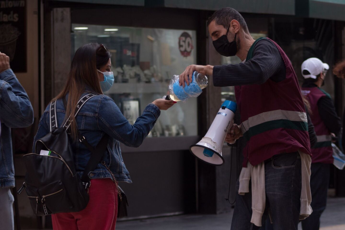 La Ciudad de México continuará en el semáforo epidemiológico color verde a pesar de la alza en contagios. En la imagen, un trabajador del gobierno capitalino reparte gel antibacterial en las inmediaciones del Centro Histórico.