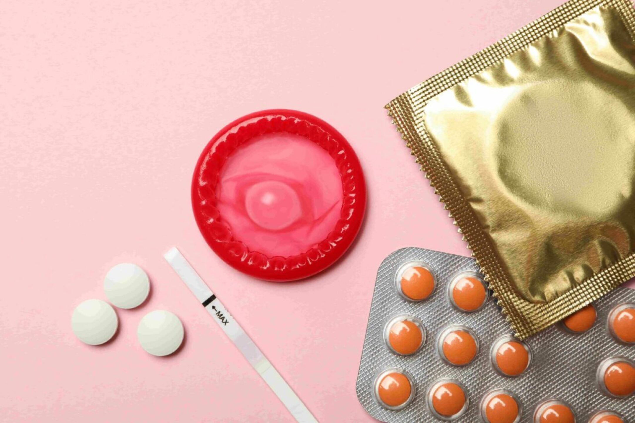 condoms-and-pills-on-pink-background-top-view-2021-08-31-23-37-51-utc-1-1280x853