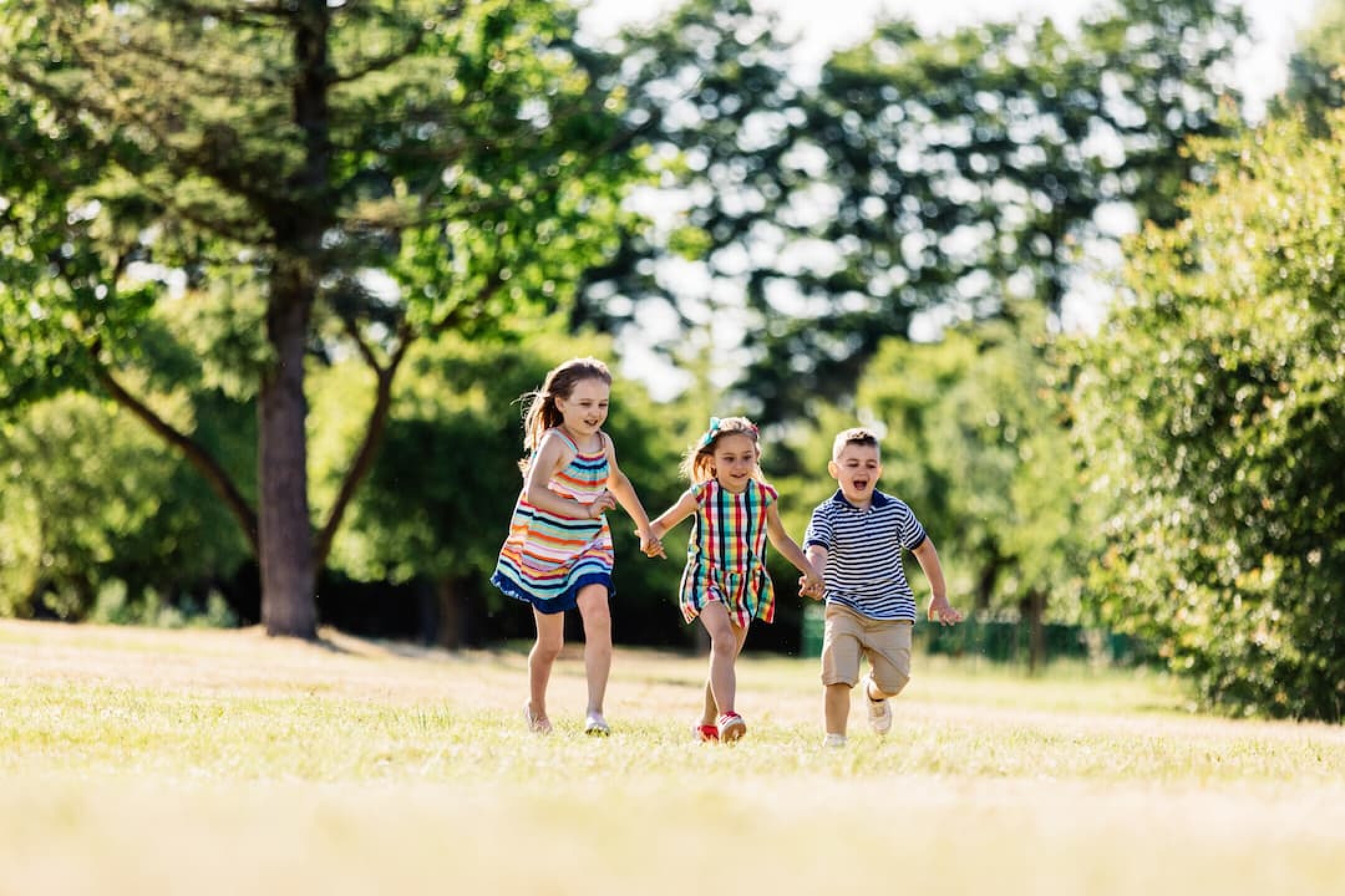 three-happy-kids-holding-hands-and-running-2023-11-27-05-27-42-utc-1-1