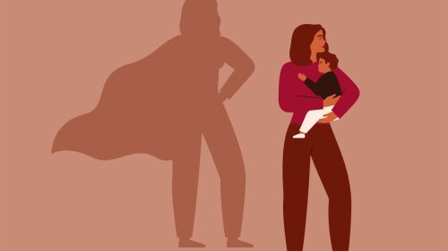 Strong working woman holds her child on the background female's shadow in the cape as a superhero. Maternity and career concept.