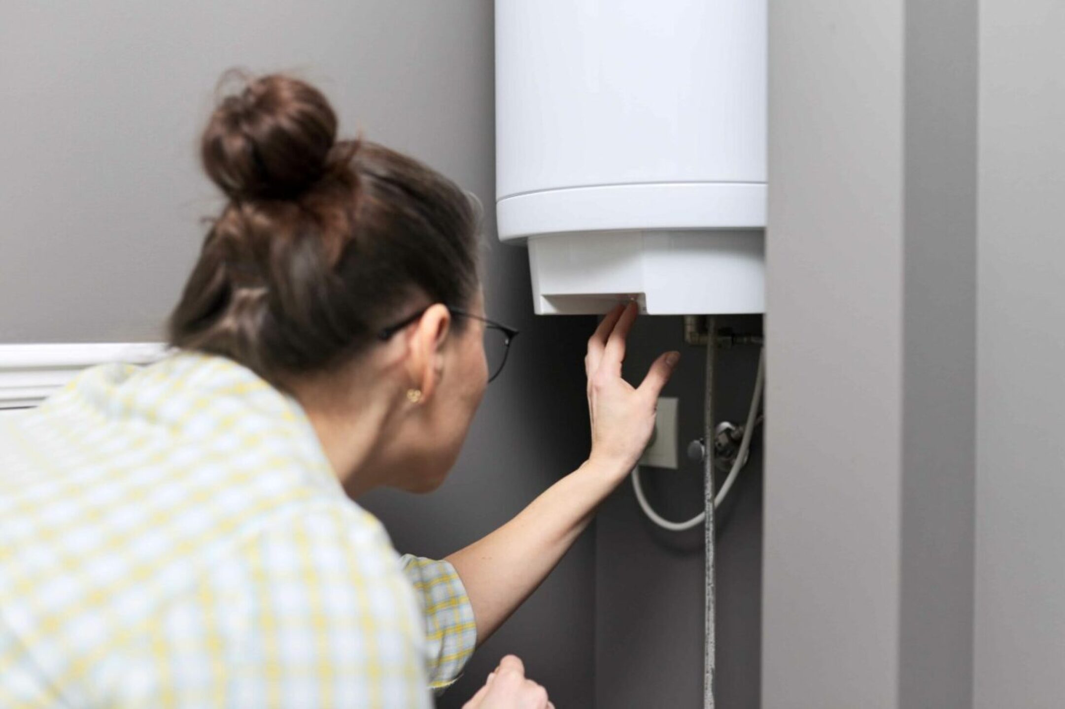 home-water-heater-woman-regulates-the-temperature-2022-01-20-19-53-30-utc-1280x853