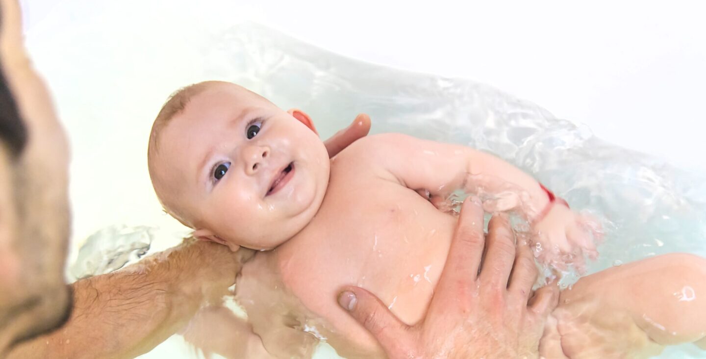 the-father-bathes-the-baby-in-the-bath-selective-2022-10-27-04-46-00-utc (1)