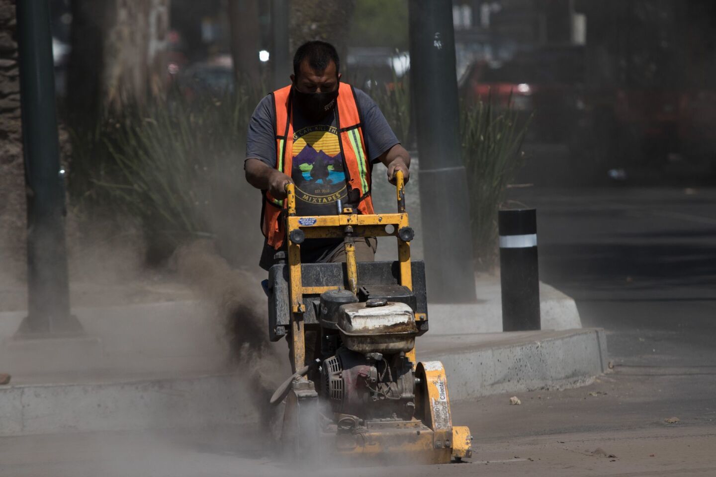 Un obrero trabaja con una cortadora de asfalto y concreto, en donde se afinan detalles de las banquetas en el cruce de Dr. Vértiz y Municipio Libre.