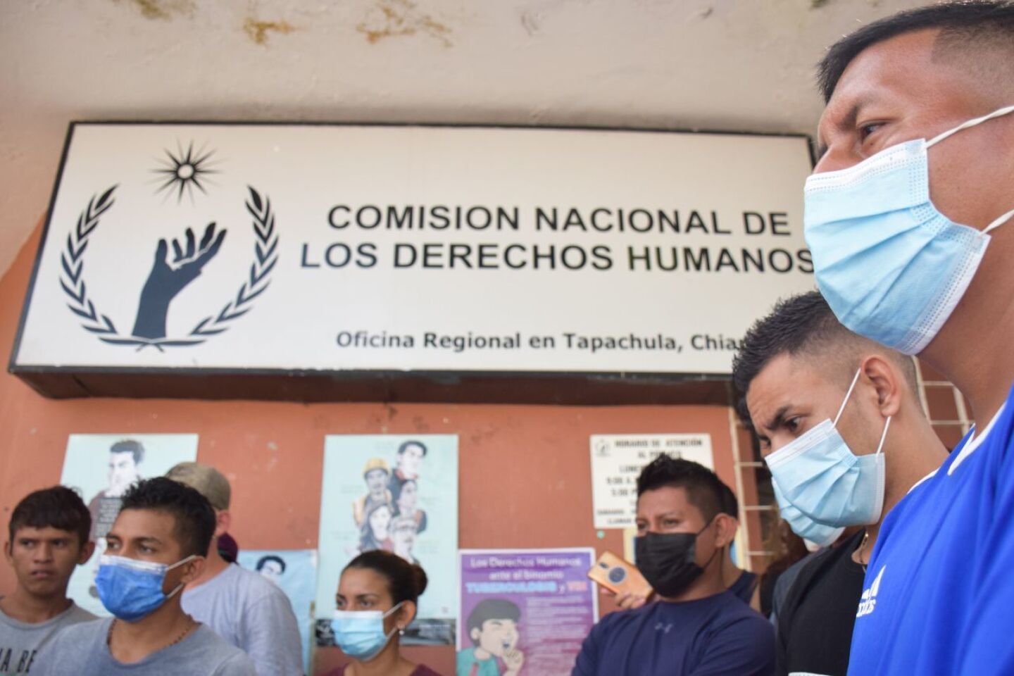 Migrantes esperan afuera de la CNDH local la entrega del documento.