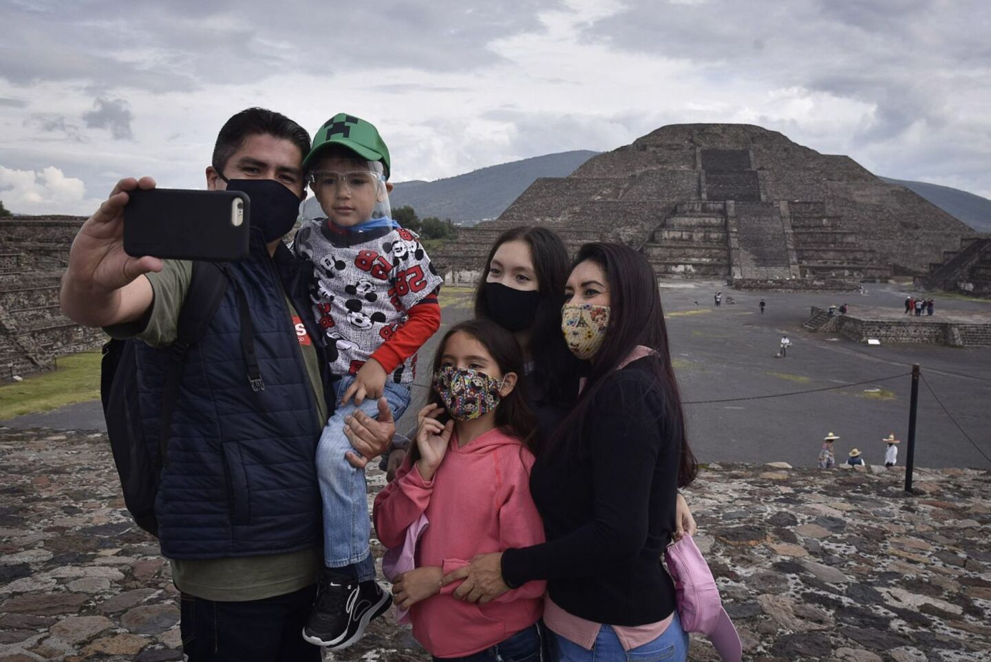 Una familia se toma una fotografía durante la reapertura de la zona Arqueológica de Teotihuacán que se mantuvo más de seis meses cerrada al público debido a la emergencia sanitaria por la pandemia de covid-19.