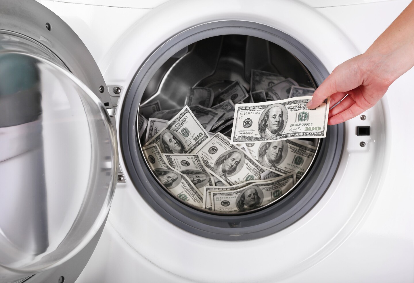 Female putting money into washing machine, closeup