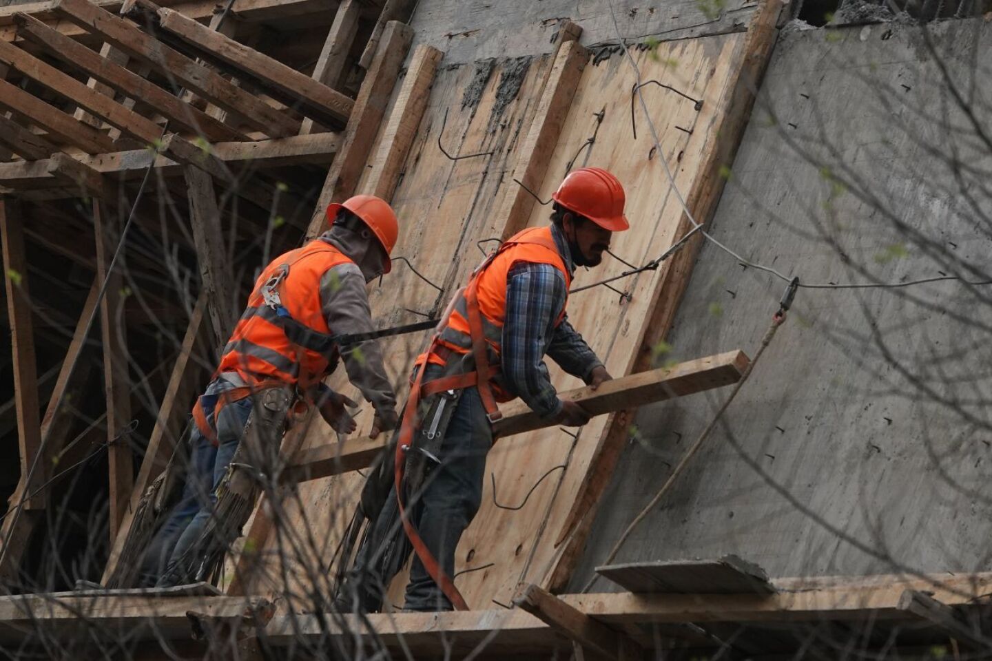 Trabajadores miden y cargan pilones en un edificio cerca del Metro Chilpancingo