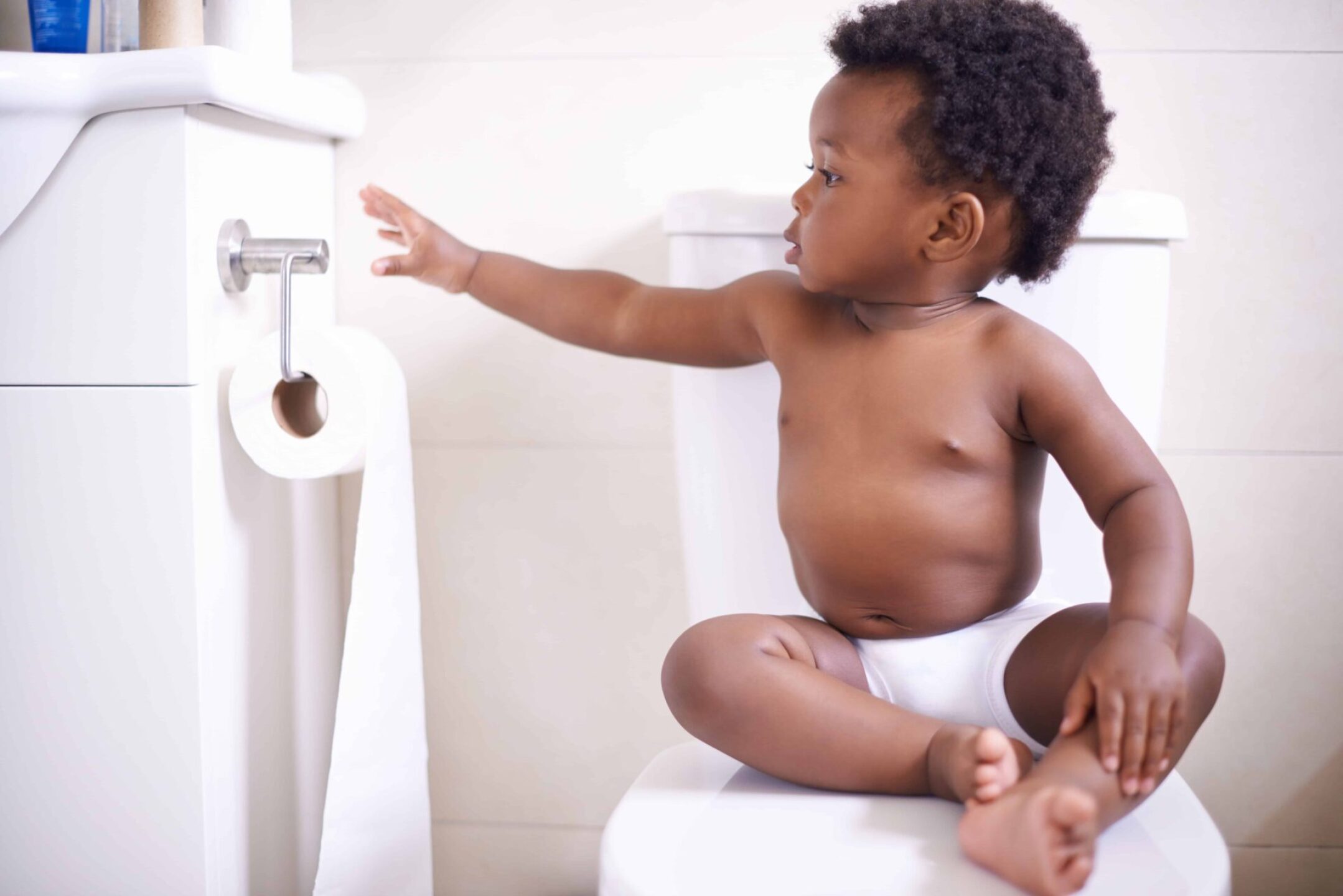 shot-of-a-baby-boy-sitting-on-the-toilet-and-reach-2022-12-23-02-17-40-utc-1