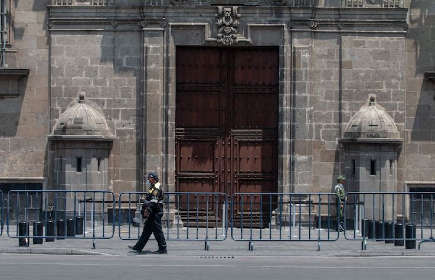 Un policía y un militar resguardas la entrada a Palacio Nacional, que desde hoy se sumó a los lugares cercados con vallas metálicas, para restringir el paso de personas, sobre todo turistas, y con ello evitar la propagación de contagio del virus COVID-19 (coronavirus)