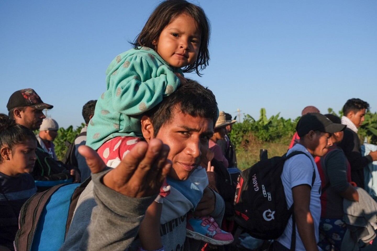 Familias acompañados de niños pequeños caminan en la caravana de migrantes centroamericanos que cruzaron esta mañana por el río Suchiate