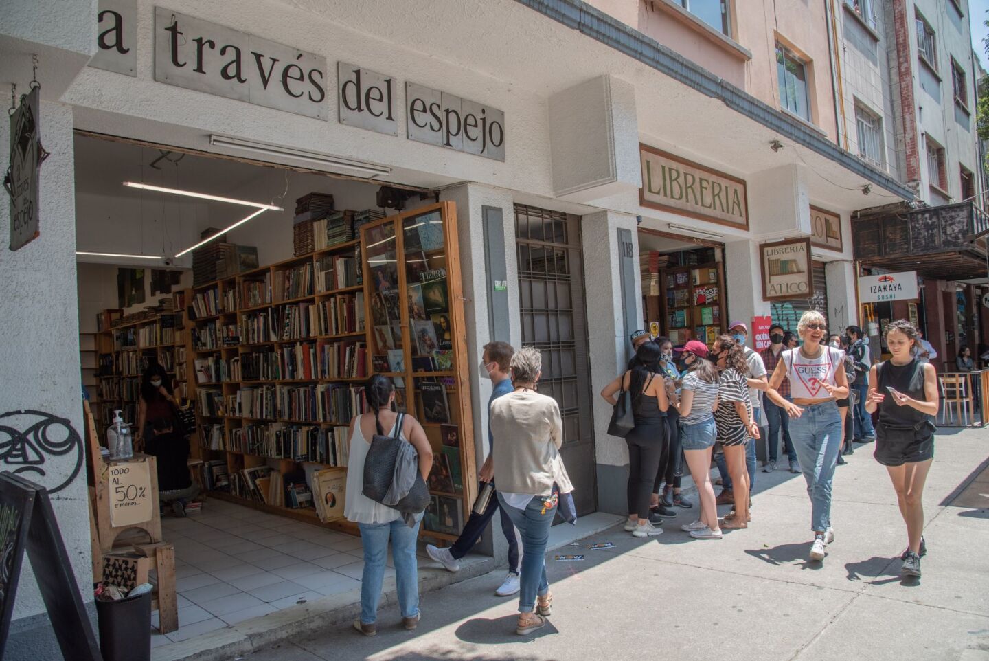 Personas esperan en una fila para poder accesar a librería "A través del Espejo" la cual ha puesto ofertas en sus libros de hasta un 50 por ciento luego de que anunciara su cierre para el próximo 30 de junio.