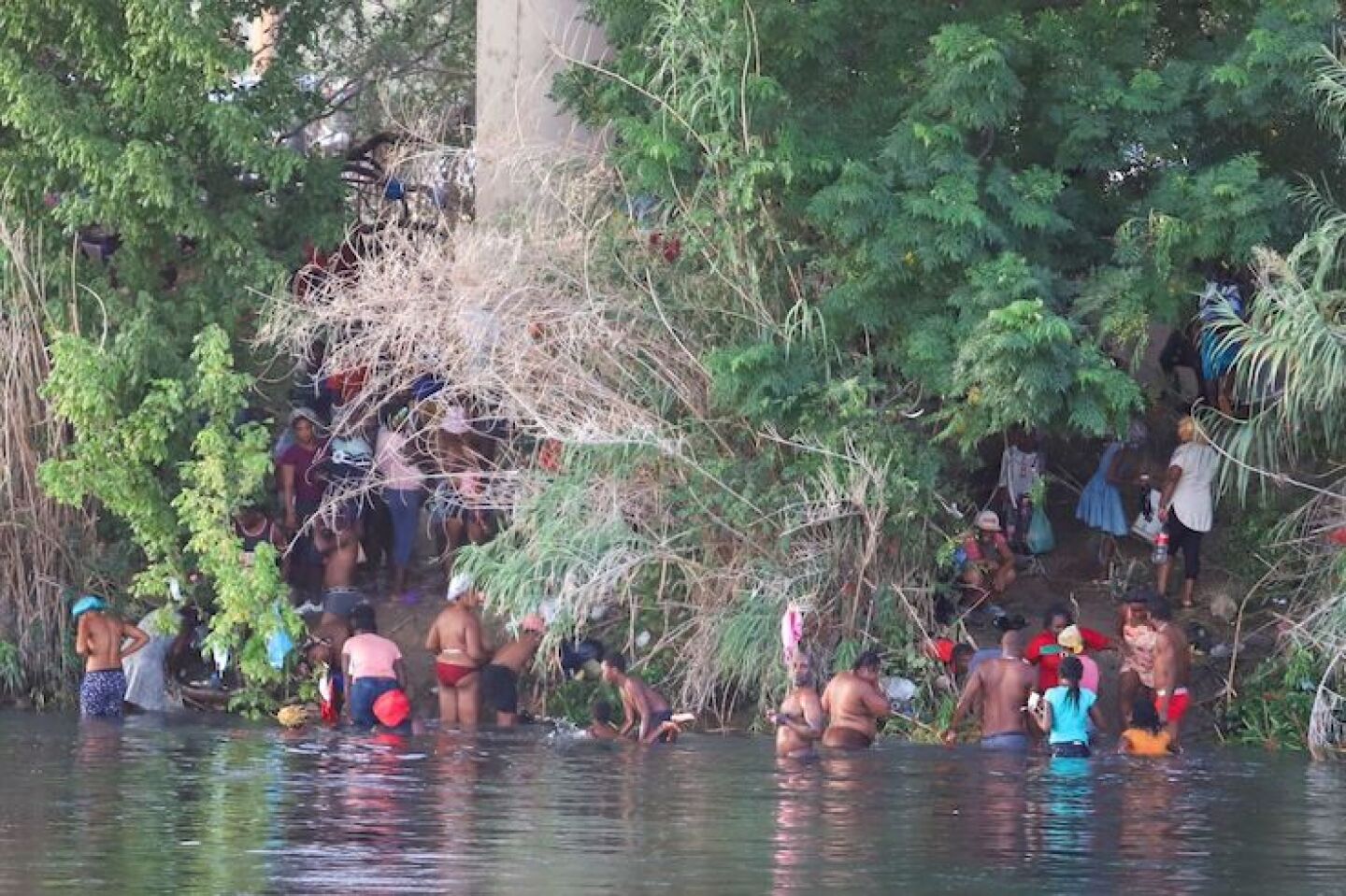 Continúa el éxodo de migrantes haitianos a través del río Bravo, tras lograr cruzar se instalan en un campamento que acondicionaron debajo de un puente de lado de Texas, en donde sos resguardados por elementos de la Border Patrol.