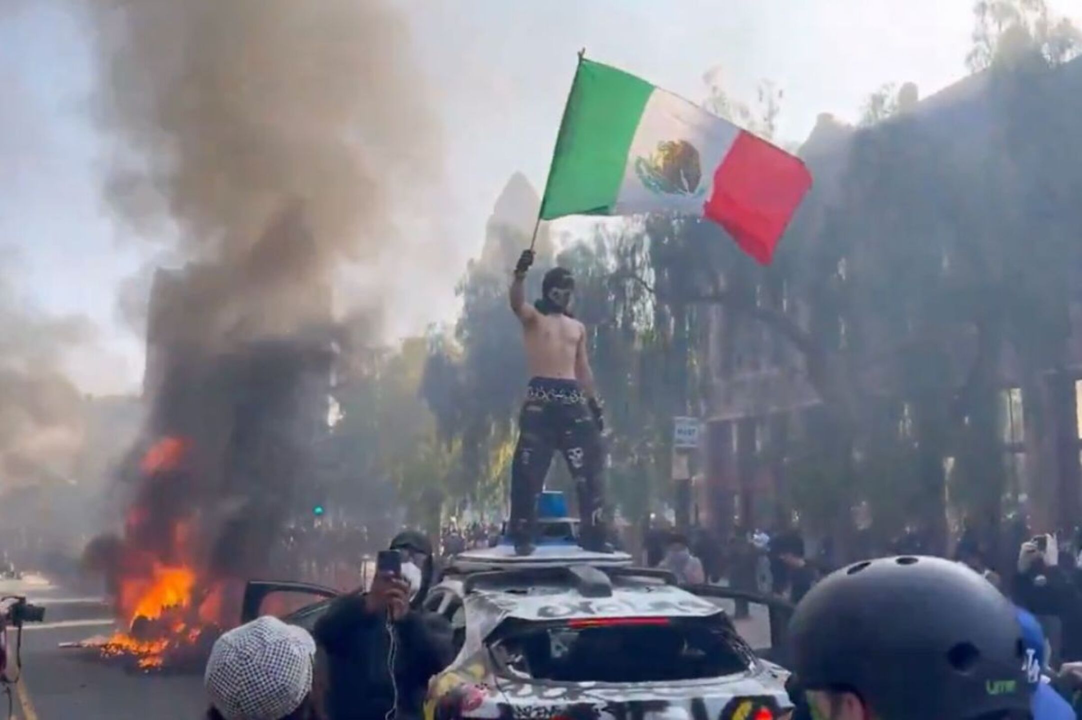Manifestante hondea bandera de México durante protesta en Los Ángeles