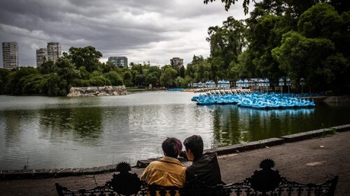 Pareja toma un descanso frente al lago de Chapultepec, reabierto luego de que la ciudad se moviera a Semaforo Naranja