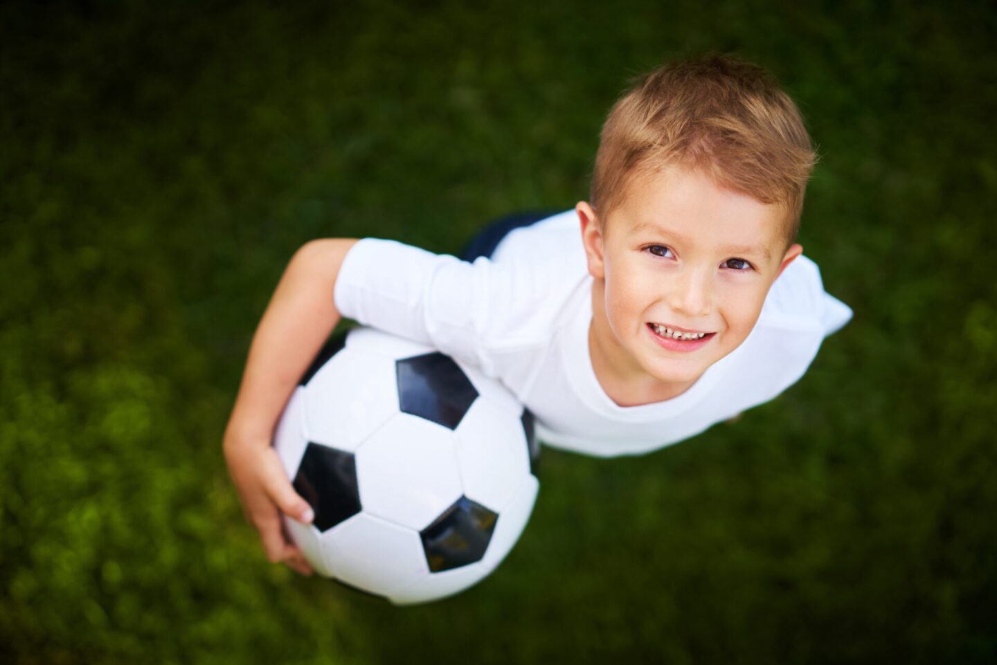 Little Boy practising soccer outdoors