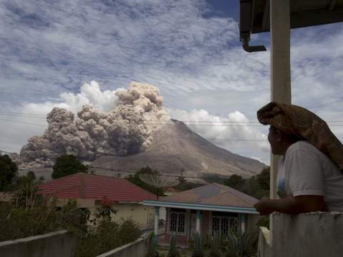 A villager watches as Mount Sinabung volcano erupts, in Kuta Tengah village, Karo Regency in Indonesia's North Sumatra