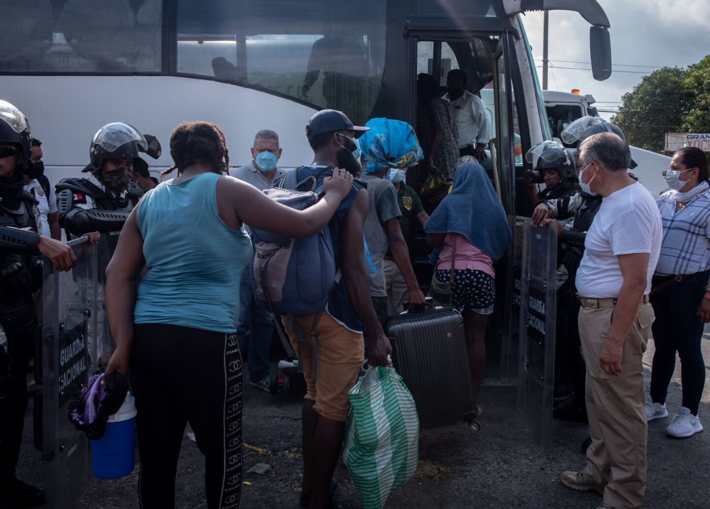Los migrantes que partieron el día de ayer en caravana de la ciudad de Tapachula hacen filas a un costado de la carretera para incorporarse a los vehículos proporcionados por el INM