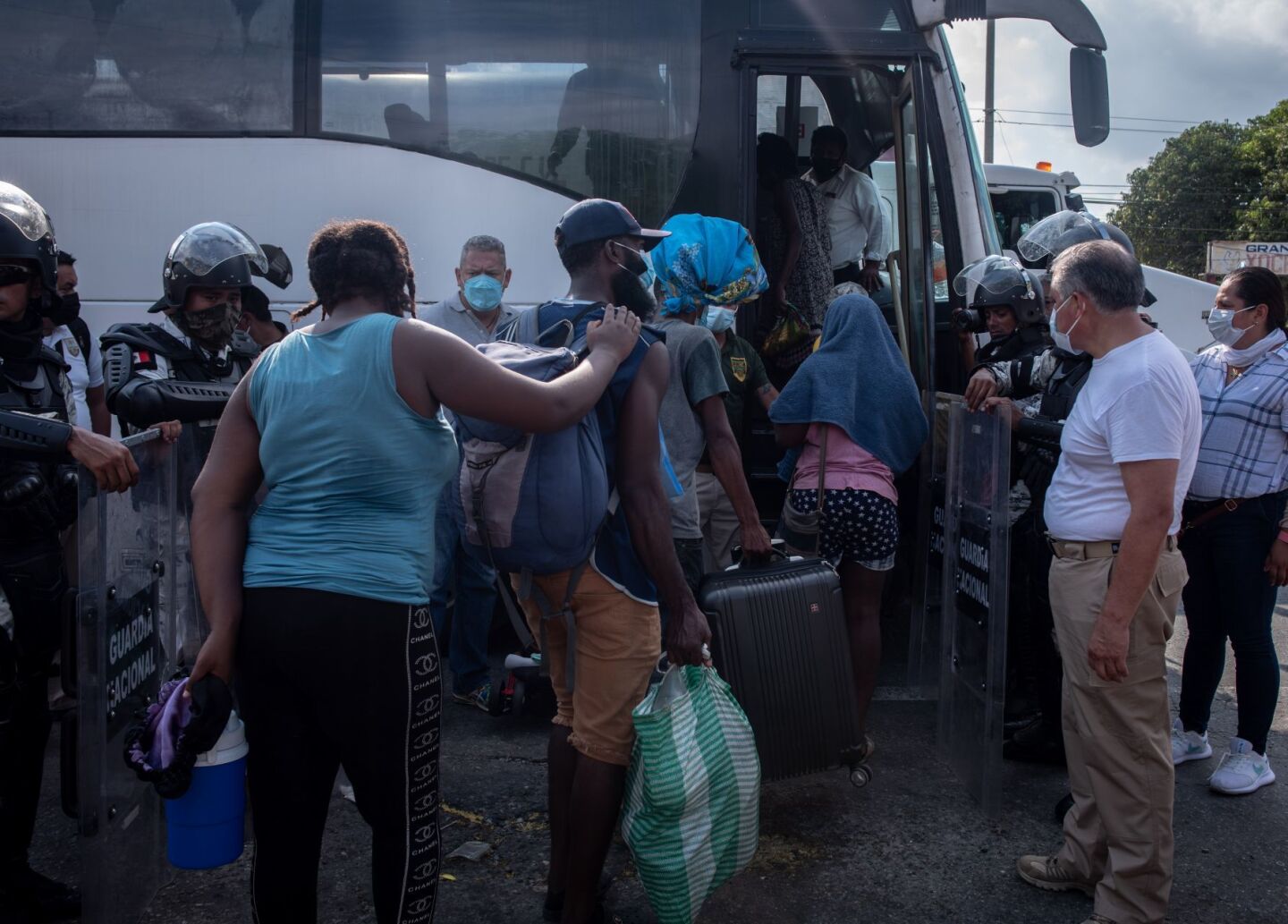 Los migrantes que partieron el día de ayer en caravana de la ciudad de Tapachula hacen filas a un costado de la carretera para incorporarse a los vehículos proporcionados por el INM