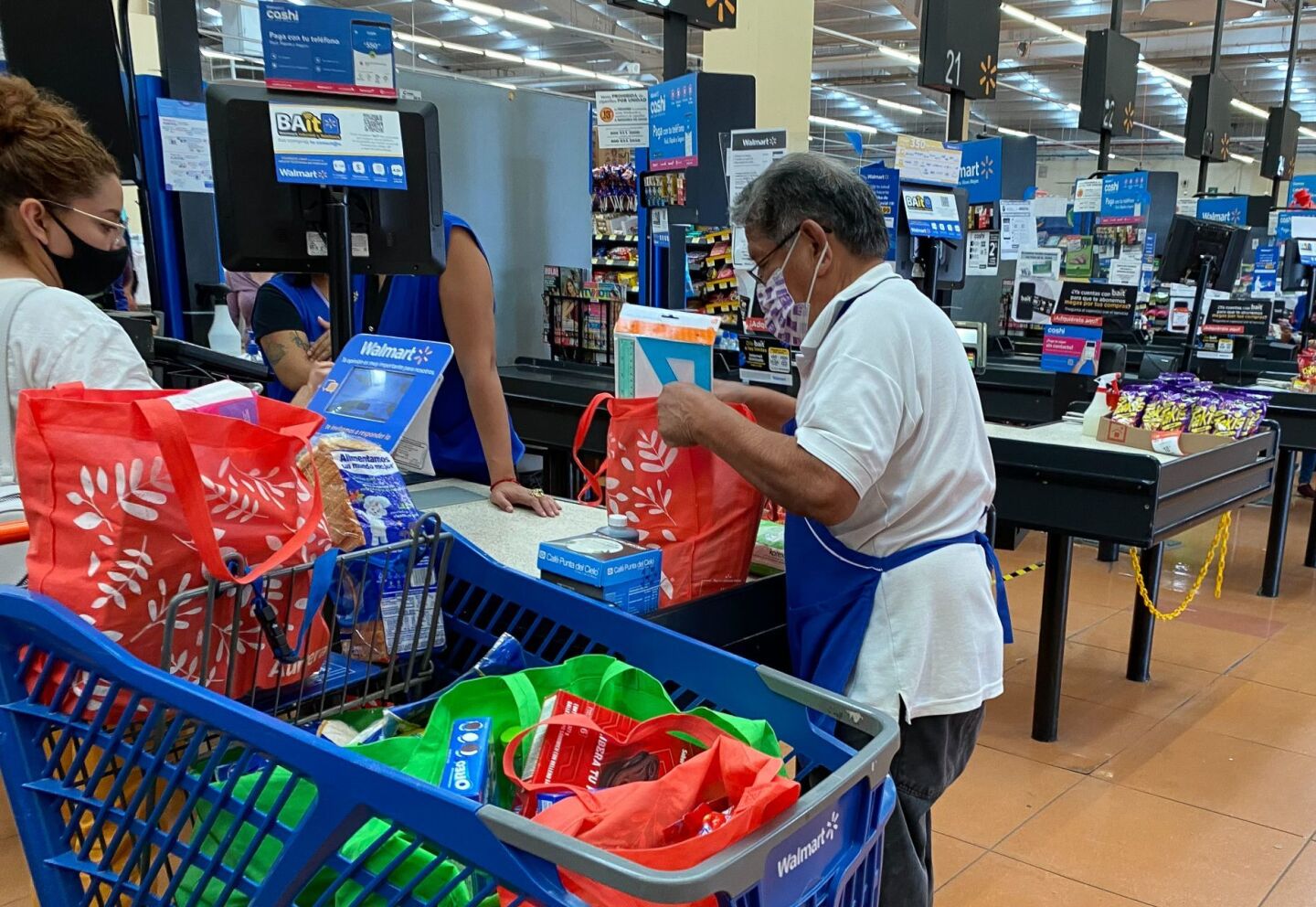 Adultos mayores regresan a su trabajo de empacadores en supermercados.