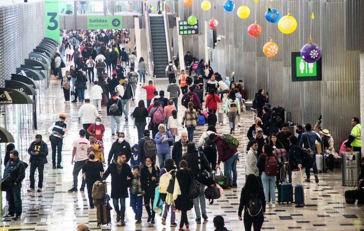 Viajeros nacionales y extranjeros viajando en el Aeropuerto Internacional de la Ciudad de México.