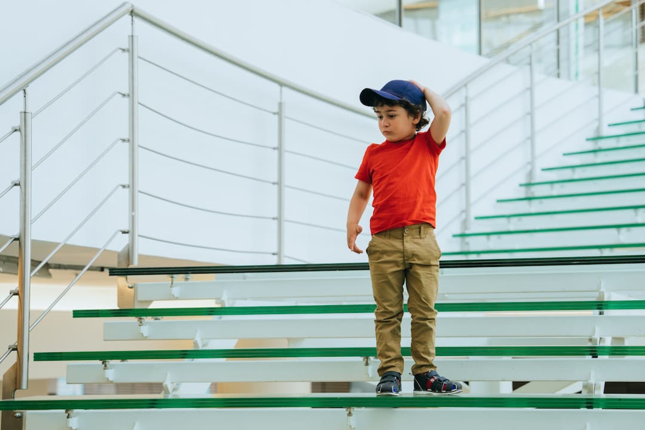 pensive-little-boy-in-casual-stands-on-stairs-at-s-2023-11-27-19-21-50-utc-1