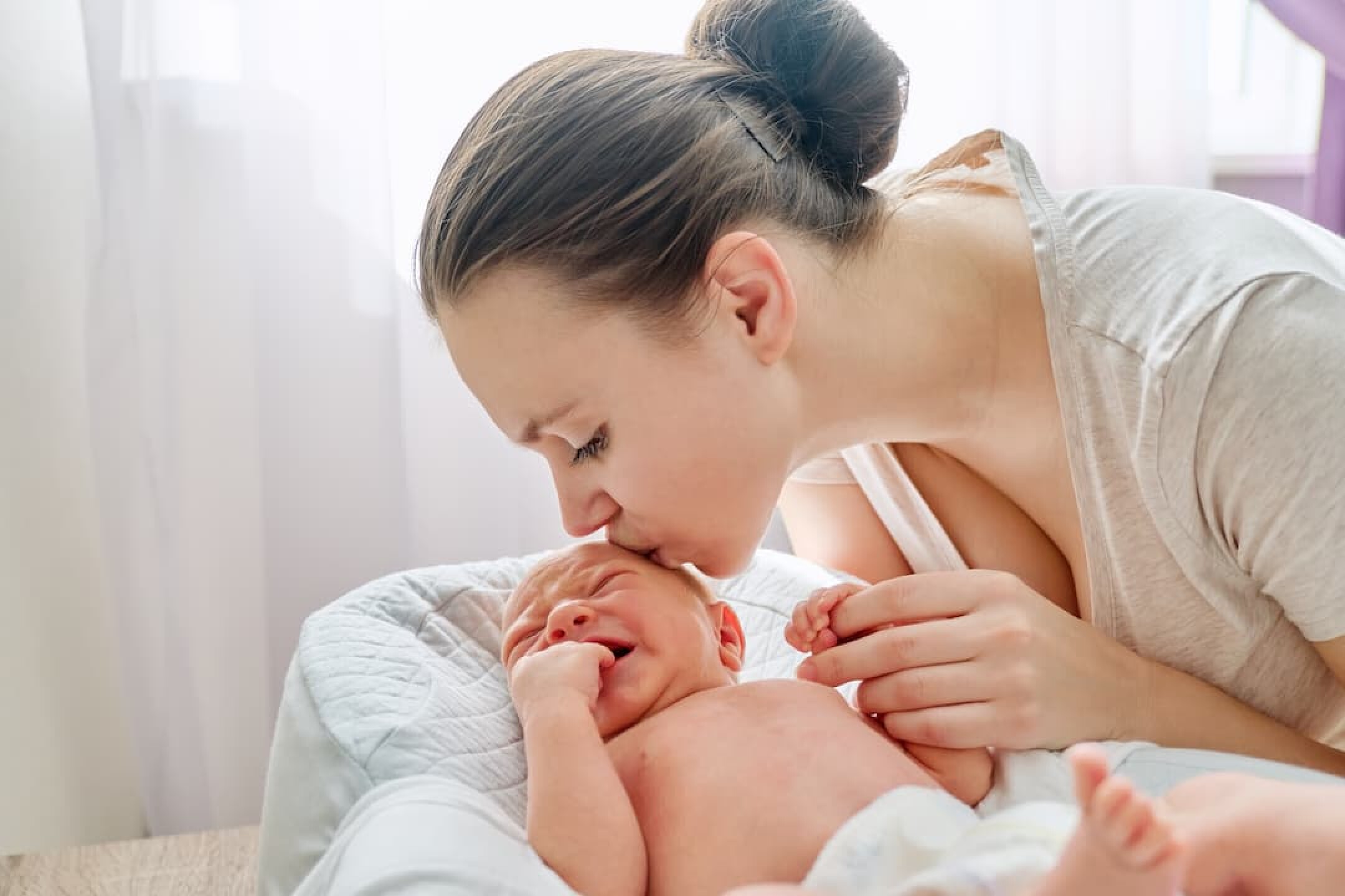 young-mom-kissing-crying-newborn-baby-son-2023-11-27-04-54-04-utc-1