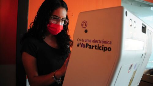 Una mujer realiza su voto electrónico por primera vez.