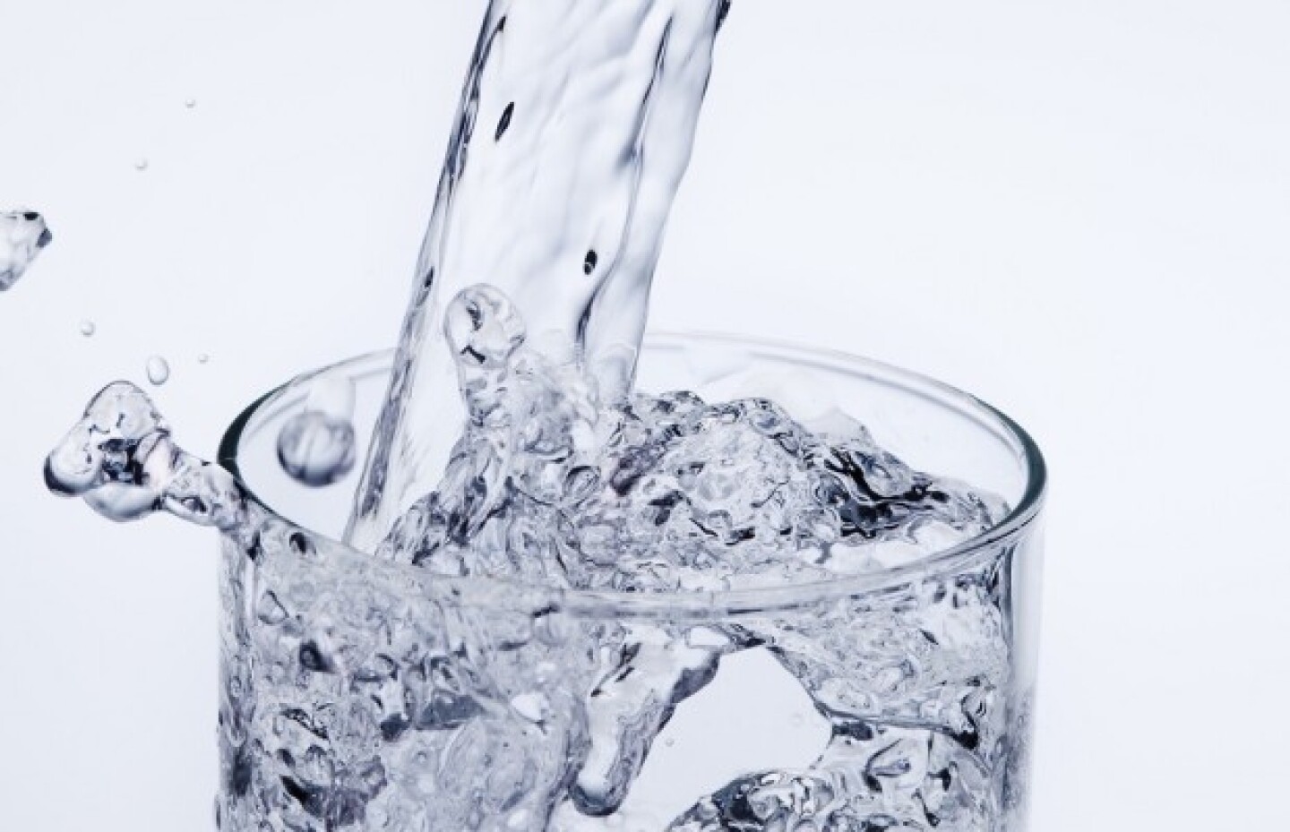 Pouring mineral water stream into a glass