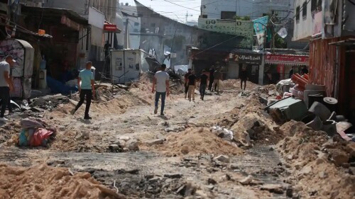 palestinos caminan por las calles después de la operación militar israelí en yenín