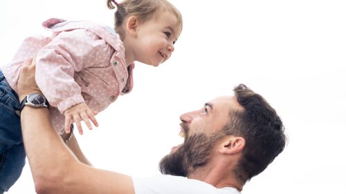 Young dad and little daughter playing outdoors