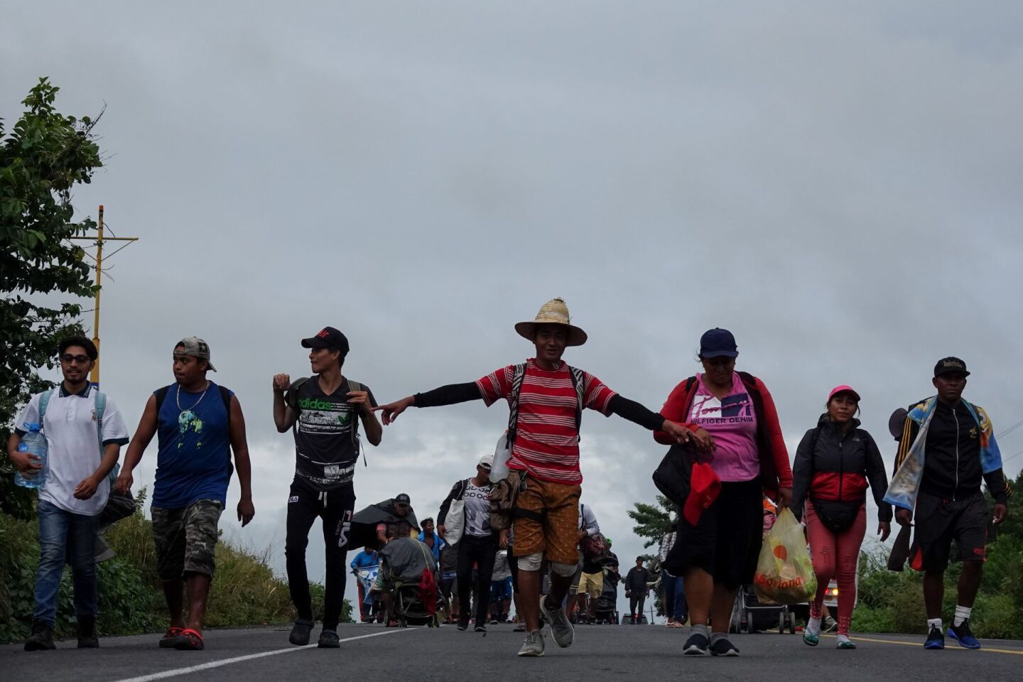 Un migrante extiende los brazos durante su recorrido por la carretera Transístmica con dirección a Sayula de Alemán, Veracruz