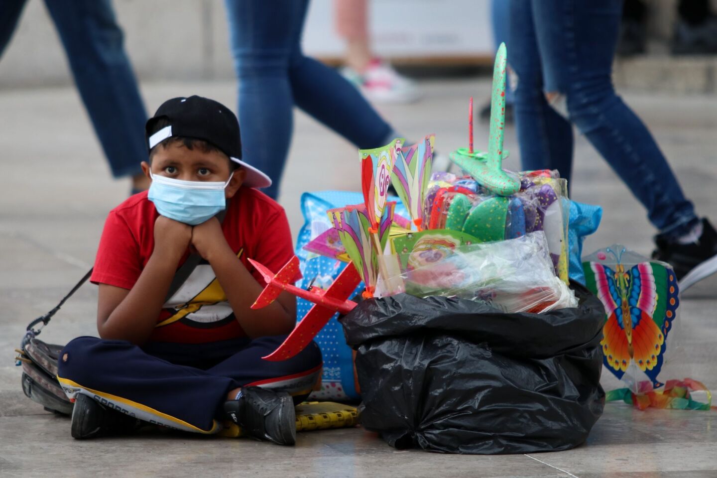 Un niño espera la compra de aviones de plástico enfrente del Palacio de Bellas Artes