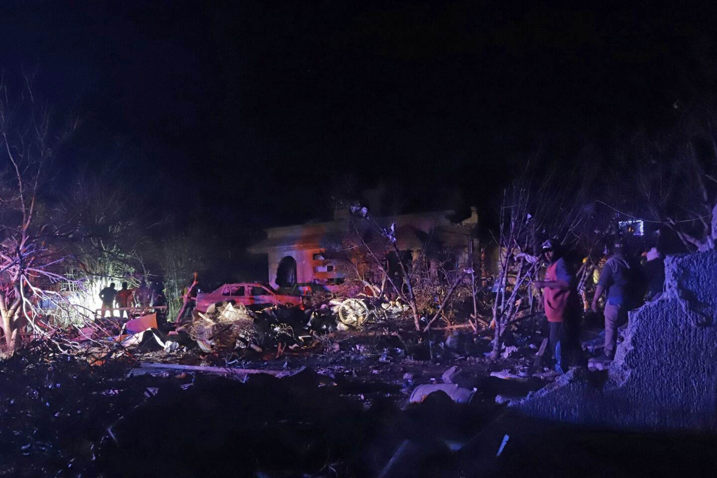Elementos de bomberos y policía apoyados por vecinos de la comunidad de Santiago Tenango en el municipio de Felipe Ángeles, trabajan en el área donde explotó un polvorín esta noche, resultando varias personas lesionadas y 4 muertos.
